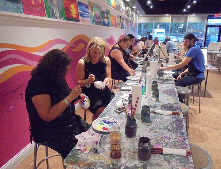 painters painting on pottery at a too cool for canvas paint & sip party